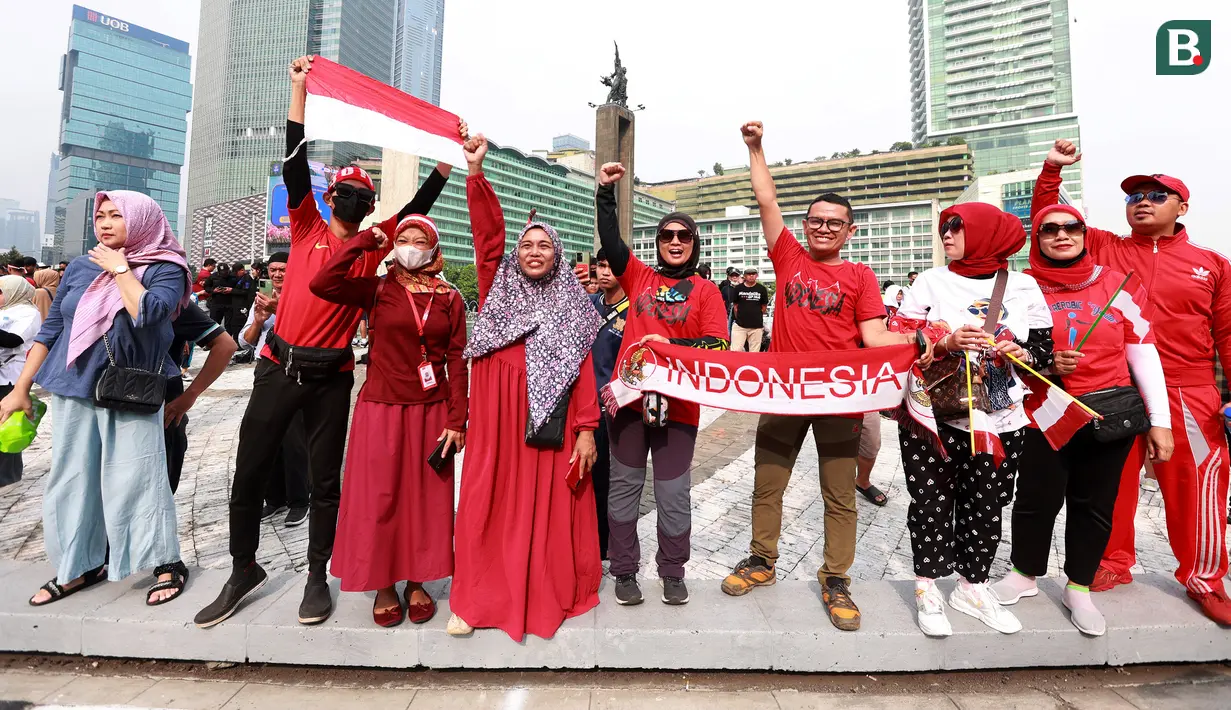 Sejumlah masyarakat saat menyambut Timnas Indonesia U-22 dan kontingen Indonesia untuk SEA Games 2023 saat pawai Kira87uara yang berlangsung dari Kemenpora hingga GBK, Jakarta, Jumat (19/05/2023). (Bola.com/M Iqbal Ichsan)