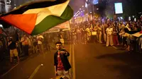 Seorang demonstran melambaikan bendera Palestina selama unjuk rasa di Madrid, Spanyol, Kamis (2/10/2025) sebagai bentuk solidaritas dengan Global Sumud Flotilla setelah kapal-kapalnya dicegat oleh angkatan laut Israel. (Dok. AP/Bernat Armangue)&nbsp;&nbsp;&nbsp;