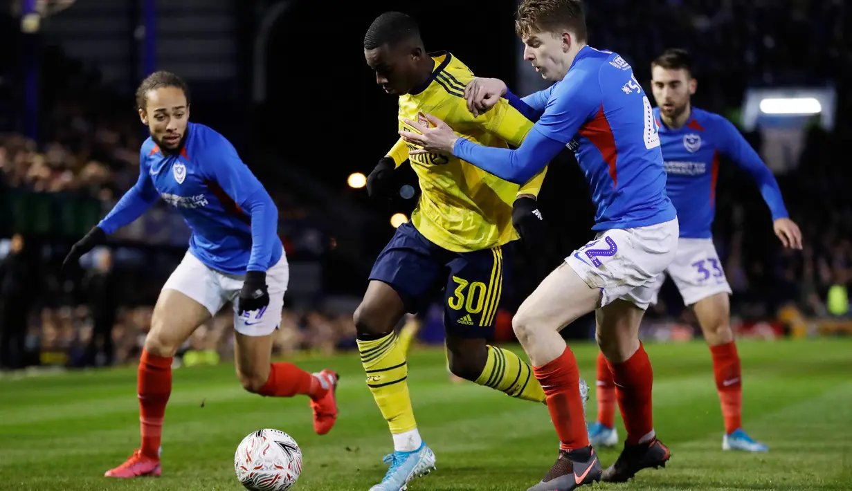 Striker muda Arsenal Eddie Nketiah berebut bola dengan pemain Portsmouth, Steve Seddon pada laga putaran lima Piala FA di Fratton Park, Senin (2/3/2020). Arsenal sukses membungkam tuan rumah Portsmouth dengan skor 2-0. (AP Photo/Kirsty Wigglesworth)