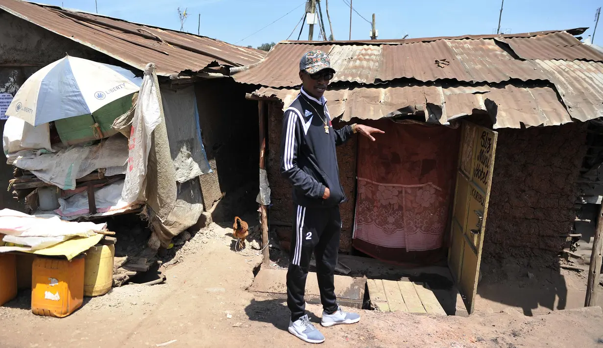 Henry Ohanga alias Octopizzo berpose di depan rumah milik kakeknya saat berkunjung ke Kibera di Nairobi, Kenya (16/1). Octopizzo akan menggunakan kesukseannya untuk membantu anak-anak di daerah kumuh tersebut. (AFP Photo/Tony Karumba)