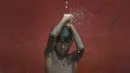 Seorang anak mandi dengan air hujan di La Guaira, Venezuela pada 26 Juli 2020, di tengah pandemi virus corona COVID-19  ketika sisa-sisa Badai Tropis Gonzalo melewati Karibia. (AP Photo / Matias Delacroix)