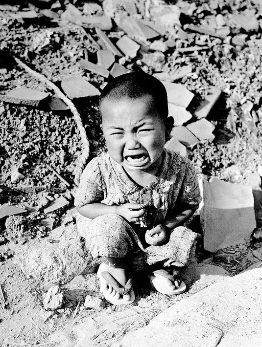 Seorang anak menangis di reruntuhan bangunan Kota Hiroshima yang hancur setelah bom atom pertama dijatuhkan oleh Angkatan Udara AS B-29 pada 06 Agustus 1945. (AFP / PHOTO) 