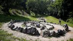 Seorang wanita berjalan di dekat bebatuan masa megalitikum di situs Piramida Matahari di Visosko, Bosnia Herzegovina, (27/7). Piramida Matahari ini diklaim dari penemuan bukit menyerupai piramida oleh Dr. Osmanagic pada 2005. (REUTERS/Dado Ruvic)