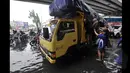 Tampak seorang wanita berusaha menaiki truk yang lewat untuk melalui banjir Jakarta, Senin (6/2/2015).  Hujan yang turun sejak malam hingga kini membuat sejumlah ruas jalan di ibukota banjir. (Liputan6.com/Faizal Fanani)