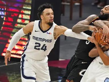 Pebasket Memphis Grizzlies, Dillon Brooks dan Brandon Clarke, berusaha merebut bola dari pebasket Cleveland Cavaliers, Andre Drummond, pada laga NBA, Senin (11/1/2021). Grizzlies menang dengan skor 101-91. (AP/Tony Dejak)