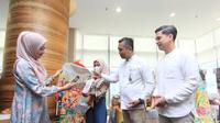 Karyawan bertransaksi menggunakan QRIS Muamalat DIN disaksikan oleh Direktur PT Bank Muamalat Indonesia Tbk Karno (kedua kanan) didampingi oleh Sekretaris Perusahaan Bank Muamalat Hayunaji (kanan) dalam kegiatan bazar Ramadan di Muamalat Tower, Kamis, (16/3/2023). (Dok Bank Muamalat)
