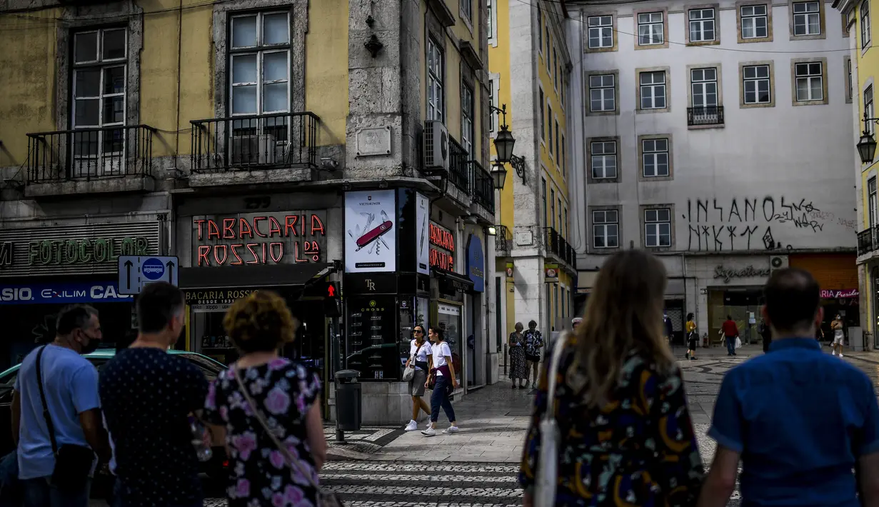 Orang-orang berjalan di pusat kota Lisbon, Portugal, Senin (13/9/2021). Portugal hari ini mengakhiri aturan wajib penggunaan masker di jalan-jalan. (PATRICIA DE MELO MOREIRA / AFP)
