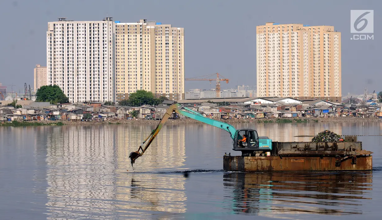 Petugas menggunakan alat berat melakukan proses pengerukan Waduk Pluit, Jakarta, Jumat (19/5). Pemprov DKI Jakarta terus melakukan pengerukan dan pembersihan Waduk Pluit. (Liputan6.com/Helmi Fithriansyah)
