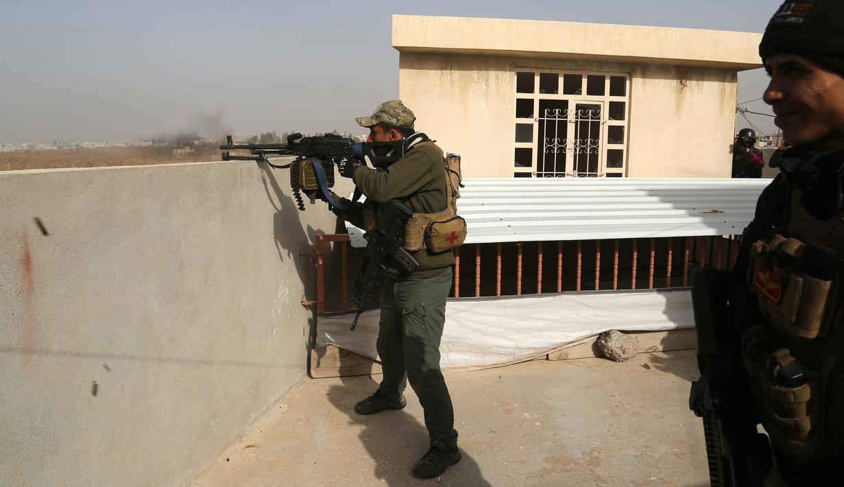Pasukan Irak membidik sasaran saat terlibat kontak senjata dengan militan ISIS di Mosul, Irak (10/1). Pertempuran dengan militan ISIS kembali terjadi saat pasukan Irak sedang melakukan evakuasi warga Mosul. (AP Photo/Khalid Mohammed)
