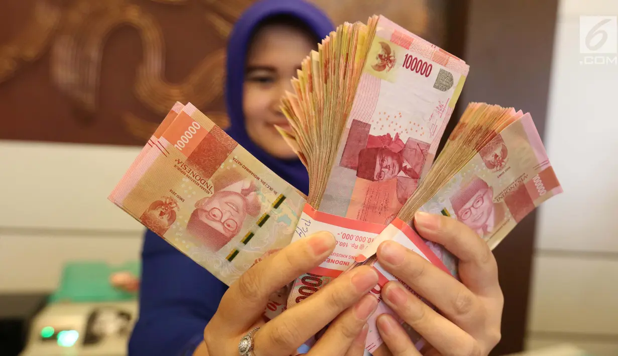 Petugas menunjukkan uang kertas rupiah di Bank BUMN, Jakarta, Selasa (17/4). Rupiah hari ini diperdagangkan dengan kisaran Rp 13.766 -Rp 13.778 per dolar AS. (Liputan6.com/Angga Yuniar)