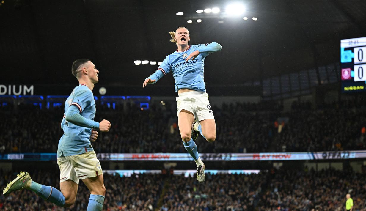 Pemain Manchester City, Erling Haaland melakukan selebrasi setelah mencetak gol ke gawang Burnley pada laga perempat final FA Cup 2022/2023 di Etihad Stadium, Minggu (19/03/2023). Mesin gol Manchester City ini menempati poisisi teratas daftar pencetak gol terbanyak sementara dengan mengoleksi 28 gol. (AFP/Oli Scarff)