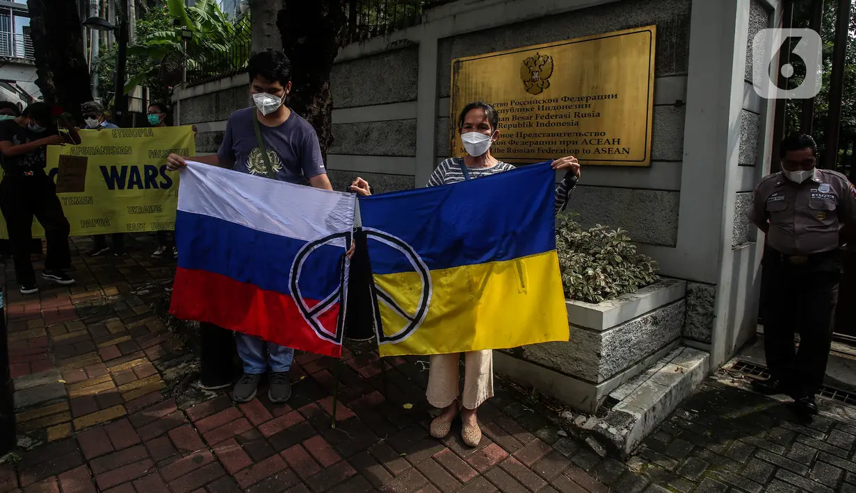 Masyarakat dari "Solidaritas untuk Rakyat Ukraina" membentangkan bendera Rusia dan Ukrainan di depan Kedubes Rusia, Jakarta, Jumat (4/3/2022). Mereka menyerukan kepada Dubes Rusia di Indonesia untuk bersuara menghentikan serangan yang dilakukan Rusia terhadap Ukraina. (Liputan6.com/Johan Tallo)