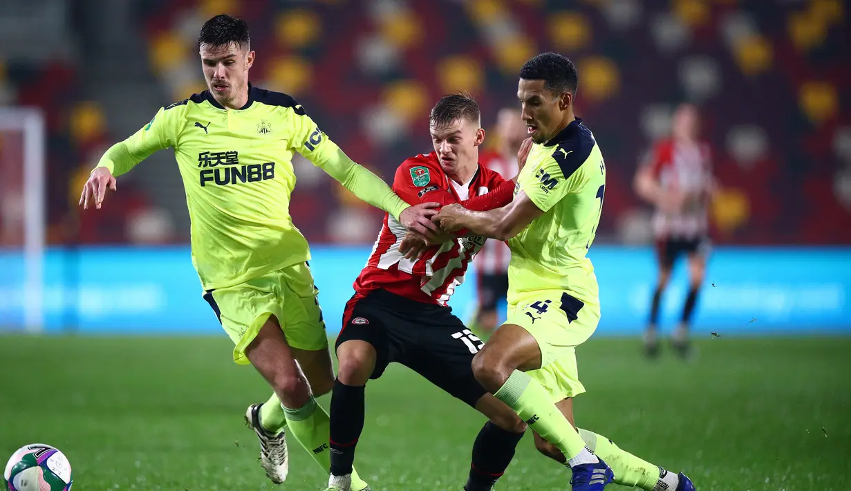 Striker Brentford, Marcus Forss (tengah), dikawal dua pemain Newcastle United dalam laga perempatfinal Piala Liga Inggris Carabao Cup di Brentford Community Stadium, Selasa (22/12/2020). Brentford menang 1-0 atas Newcastle United (AFP/Hannah McKay/Pool)