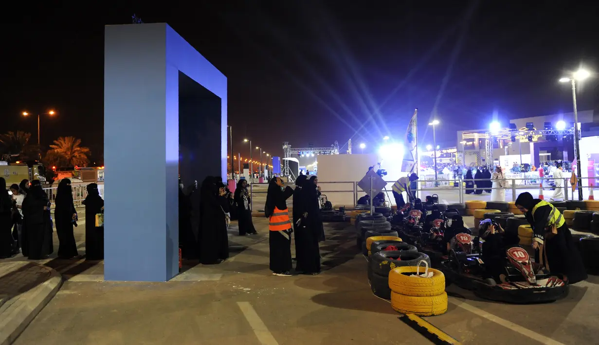Para wanita antre untuk mencoba gokart selama workshop di Ibu Kota Riyadh, Arab Saudi, Kamis (21/6). Pemerintah Arab Saudi kini telah memperbolehkan kaum wanita untuk mengendarai kendaraan. (FAYEZ NURELDINE/AFP)
