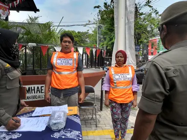 Warga pelanggar PSBB dihukum menyanyikan lagu Indonesia Raya saat razia di Jalan Raya Cinere, Depok, Jawa Barat, Senin (24/8/2020). Razia ditujukan bagi warga yang tidak mengenakan masker untuk menekan penyebaran COVID-19. (merdeka.com/Arie Basuki)