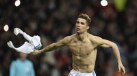 Striker Real Madrid, Cristiano Ronaldo, melepas baju untuk melakukan selebrasi usai mencetak gol ke gawang Juventus pada laga Liga Champions di Stadion Santiago Bernabeu, Rabu (11/4/2018). Real Madrid takluk 1-3 dari Juventus. (AFP/Oscar Del Pozo)