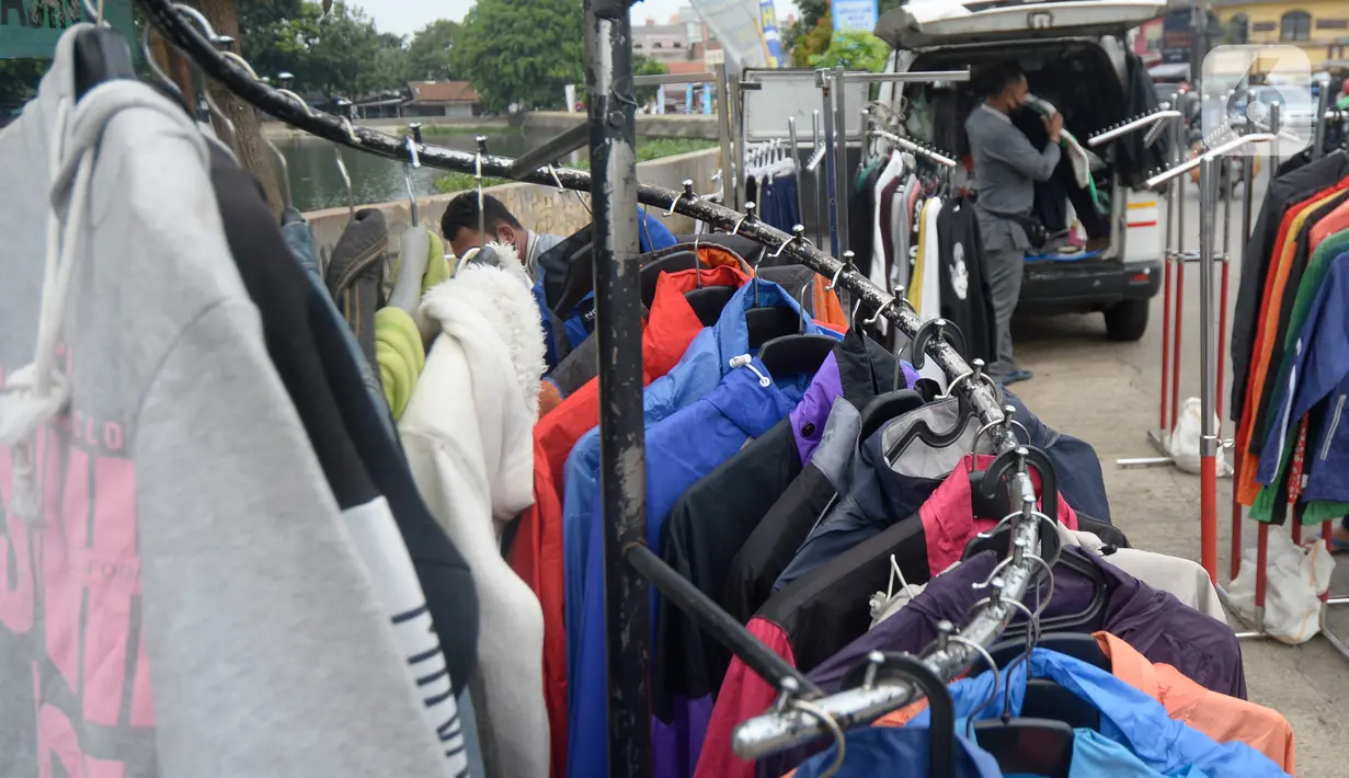 Ridwan (40) menata baju seken (baju bekas) impor di Pamulang, Tangerang Selatan, Banten, Senin (29/9/2020). Sebelumnya Ridwan merupakan pengusaha alat sewa pesta, karena kondisi pandemi Covid-19 sepi hajatan iya beralih menjual baju bekas demi memenuhi kebutuhan sehari-hari. (merdeka.com/Dwi Narwoko