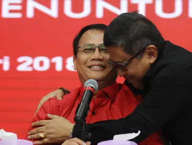 Politisi PDIP, Ahmad Basarah (kiri) dipeluk Sekjen Hasto Kristiyanto usai menyatakan kesiapan maju dalam bursa bakal Cawagub Jatim di Jakarta, Selasa (9/1). Basarah menyatakan siap apabila diberi tugas oleh Ketum PDIP. (Liputan6.com/Helmi Fithriansyah)
