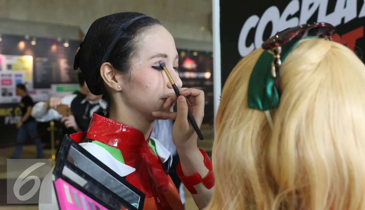 Peserta cosplay sedang didandani pada acara Indonesia Comic Con 2016 di Jakarta, Sabtu (1/10). Indonesia Comic Con 2016 bertema "We Are Pop Culture" ini digelar di Hall A dan B, JCC Senayan. (Liputan6.com/Herman Zakharia)