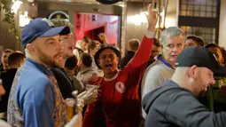 Pendukung Liverpool bernyanyi dan mendukung tim mereka di sebuah pub di alun-alun Campo de 'Fiori Roma, Italia (1/5). Pada leg pertama Liverpool menang telak 5-2 atas AS Roma. (AP Photo/Andrew Medichini )