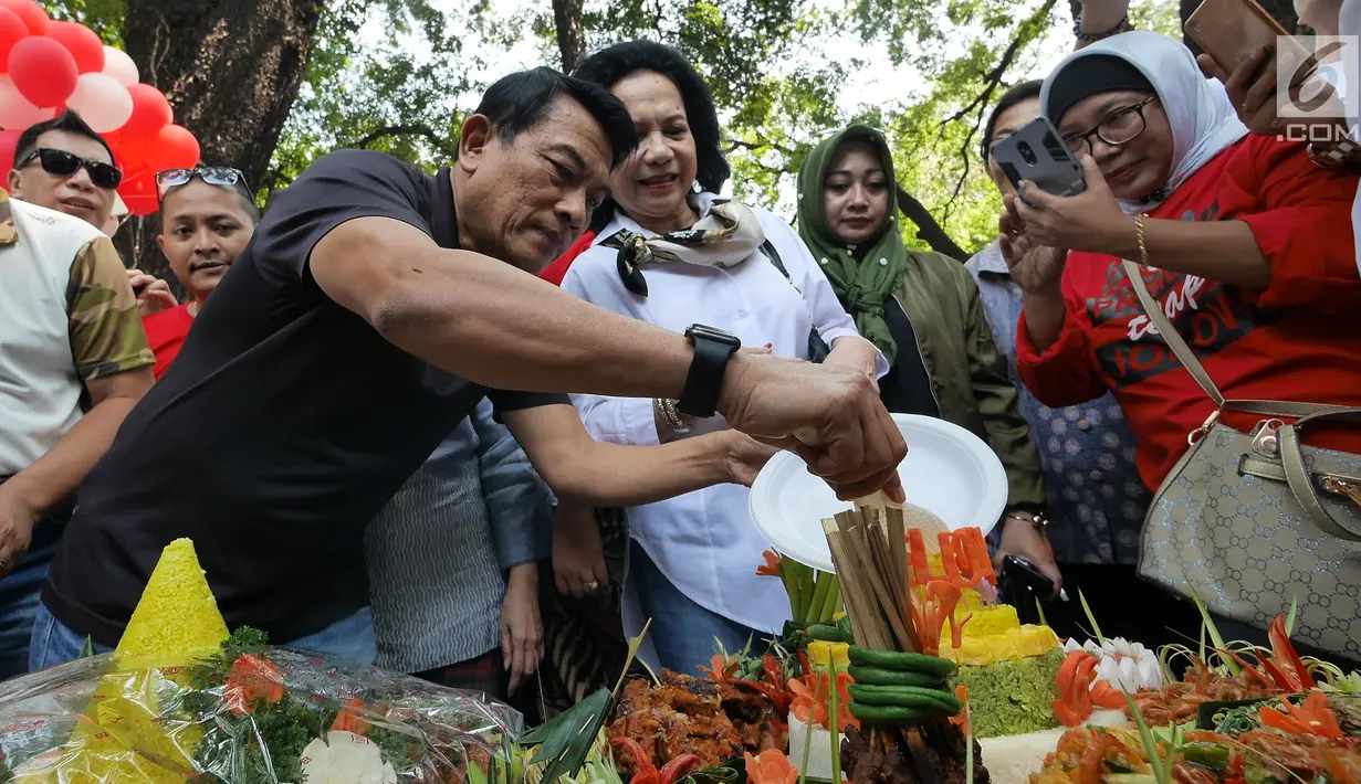 Kepala Kantor Staf Presiden (KSP), Moeldoko memotong tumpeng saat merayakan ulang tahunnya yang ke-61 di Taman Suropati, Jakarta, Minggu (8/7). Moeldoko merayakan momen pergantian tahunnya bersama istri dan keluarga. (Liputan6.com/Herman Zakharia)