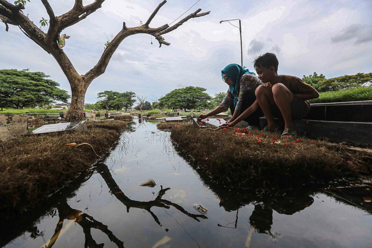 FOTO: Perjuangan Warga Berziarah di Tengah Banjir TPU Semper