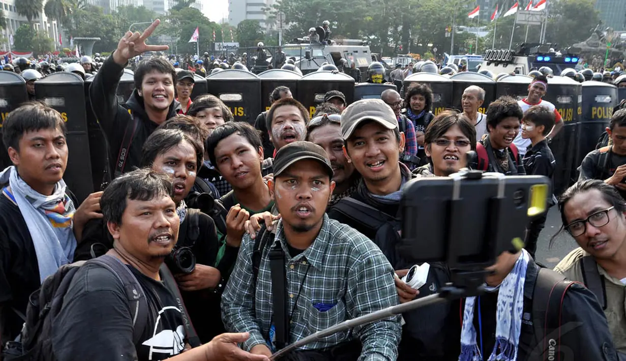 Para pewarta foto itu mengabadikan gaya unik mereka di depan barisan polisi yang memblokade jalan, Jakarta, Kamis (21/8/14).(Liputan6.com/Miftahul Hayat)