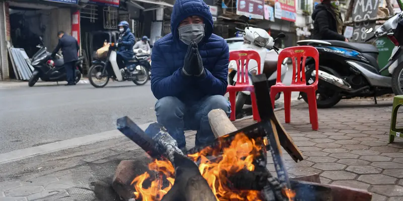 Warga Hanoi di Vietnam Bakar Kayu untuk Lawan Cuaca Dingin