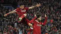 Dua pemain Liverpool, Roberto Firmino dan Mohamed Salah, merayakan gol yang dicetak ke gawang AS Roma pada laga leg pertama semifinal Liga Champions di Stadion Anfield, Rabu (25/4/2018) dini hari WIB. (Peter Byrne/PA via AP)