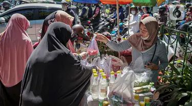 Penjual bunga tabur melayani pembeli di TPU Karet Tengsin, Jakarta, Minggu (27/3/2022). Sebagian warga memanfaatkan waktu jelang Ramadan menjadi penjual bunga tabur musiman untuk memenuhi kebutuhan ziarah ke makam yang dijual Rp 5.000 - Rp 20.000 per kantong plastik. (Liputan6.com/Faizal Fanani)