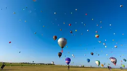 Ratusan balon udara terbang di pangkalan udara Chambley-Bussieres, Hagéville, Prancis, Senin (29/7/2019). Acara itu disebut sebagai salah satu festival balon udara terbesar di dunia. (Jean-Christophe VERHAEGEN/AFP)