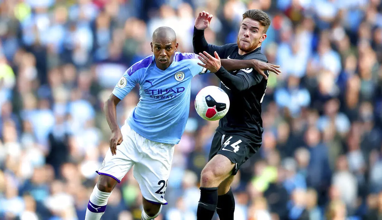 Gelandang Manchester City, Fernandinho, berebut bola dengan pemain Brighton and Hove Albion, Aaron Connolly, pada laga Premier Leauge 2019 di Stadion Etihad, Sabtu (31/8). Manchester City menang 4 gol tanpa balas. (AP/Nick Potts)