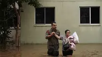 Seorang tentara membantu seorang wanita mengungsi dari lingkungan yang terendam hujan lebat di Canoas, Negara Bagian Rio Grande do Sul, Brasil, Sabtu (4/5/2024).&nbsp;(Dok. AP Photo/Carlos Macedo)