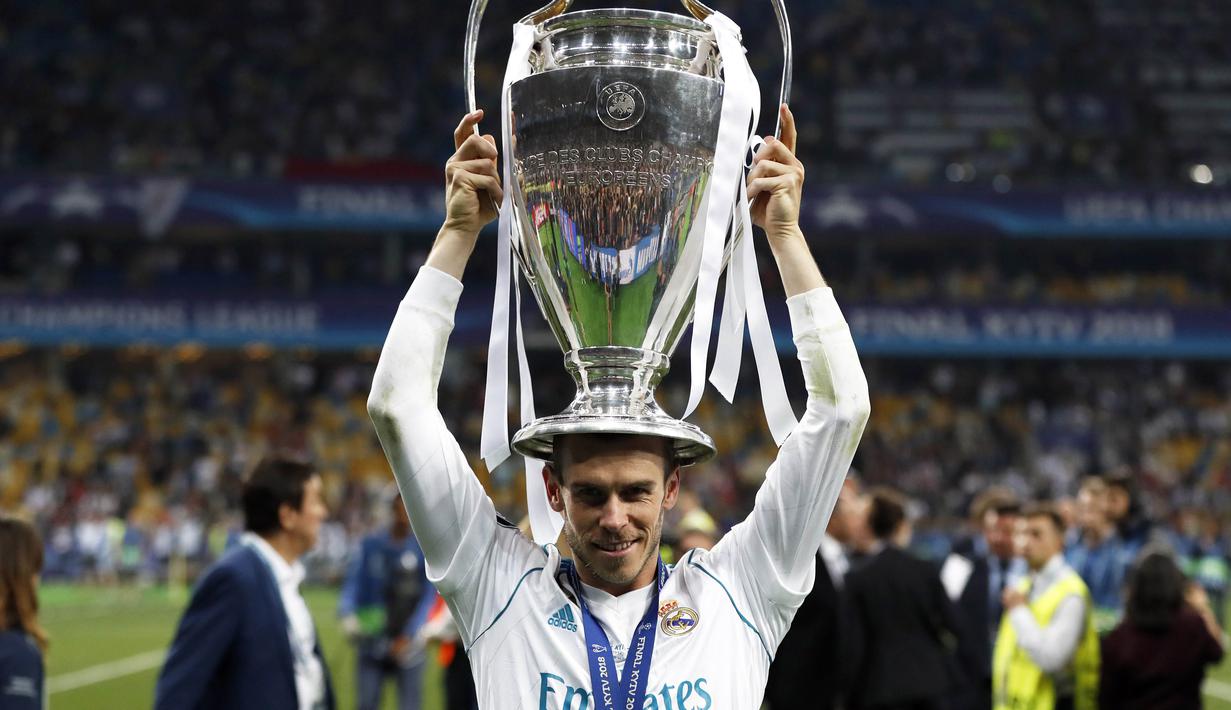 Penyerang Real Madrid, Gareth Bale, melakukan selebrasi angkat trofi usai menjuarai Liga Champions di Stadion NSC Olimpiyskiy, Kiev, Minggu (27/5/2018). Real Madrid menang 3-1 atas Liverpool. (AP/Pavel Golovkin)