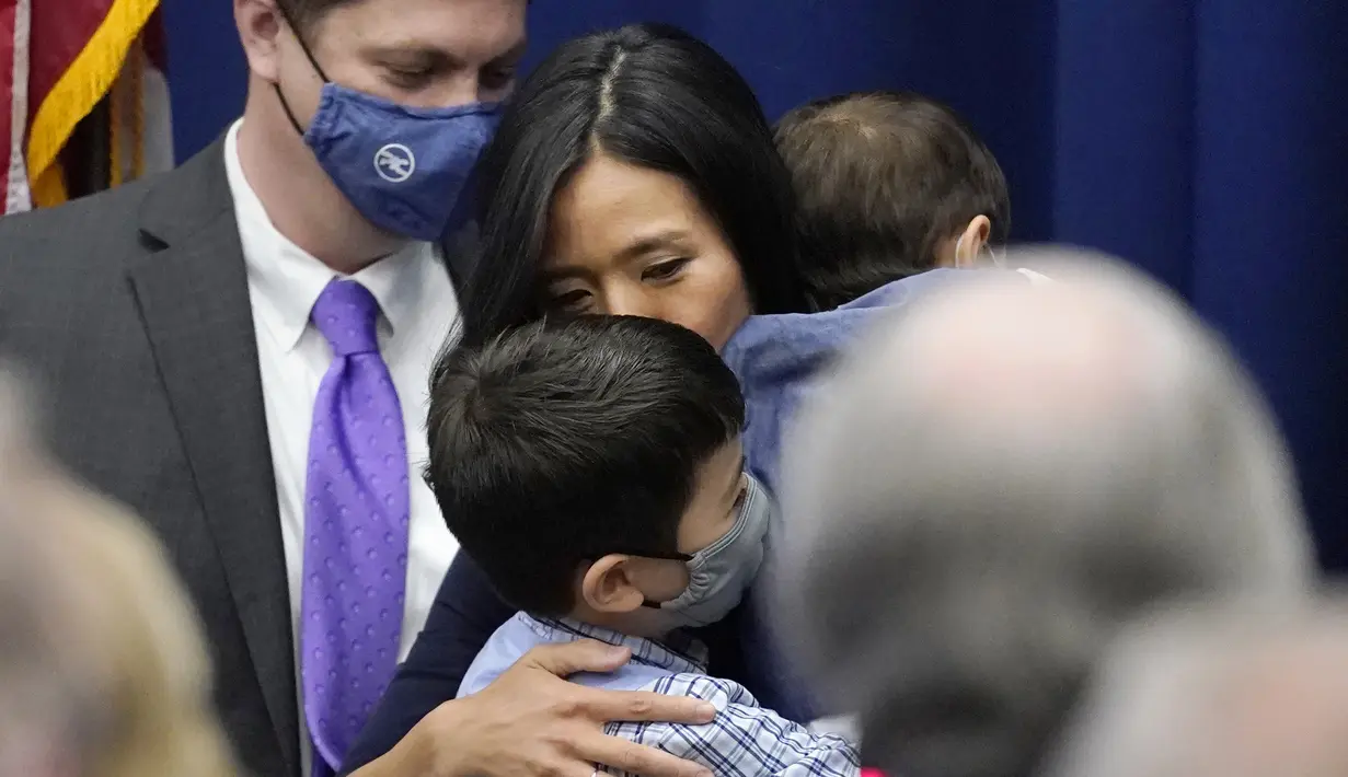 Michelle Wu mencium putranya Blaise, sambil menggendong sang anak Cass, setelah Wali Kota Boston di Balai Kota Boston, Selasa (16/11/2021). Michelle Wu juga merupakan orang kulit berwarna pertama sepanjang sejarah, yang berhasil terpilih dalam Pemilihan Wali Kota Boston. (AP Photo/Charles Krupa)