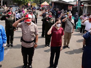 Ratusan masyarakat yang mengikuti vaksin Covid-19 memberi hormat saat memperingati HUT ke-76 RI di Jakarta, Selasa (17/8/2021). Hal tersebut dilakukan untuk mengenang jasa para pahlawan dalam memperjuangkan Kemerdekan Republik Indonesia. (Liputan6.com/Angga Yuniar)
