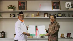 Direktur KSKK Madrasah Ditjen Pendis Kemenag Dr. A. Umar, M.A (kiri) dan Presdir Smartfren Merza Fachys (kanan) usai menandatangani nota kerjasama pemberian kartu perdana Smartfren gratis untuk Madrasah se-Indonesia untuk mendukung program PJJ, di Jakarta, Senin (21/9/2020). (Liputan6.com/HO/Agus)