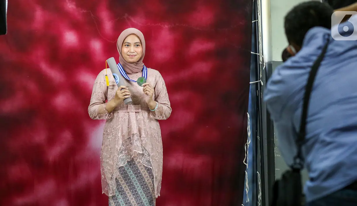Siswi sedang foto kelulusan pada acara Wisuda Pelepasan Kelas XII di Madrasah Aliyah Annajah, Petukangan, Jakarta, Kamis (18/6/2020). Sebanyak 85 siswa mengikuti Wisuda Drive Thru untuk menghindari kerumunan dan sebagai upaya mencegah penyebaran virus Covid-19. (Liputan6.com/Fery Pradolo)
