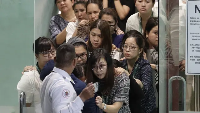 Para sandera berjalan keluar dari V-Mall di Manila, Filipina pada hari Senin, 2 Maret 2020.