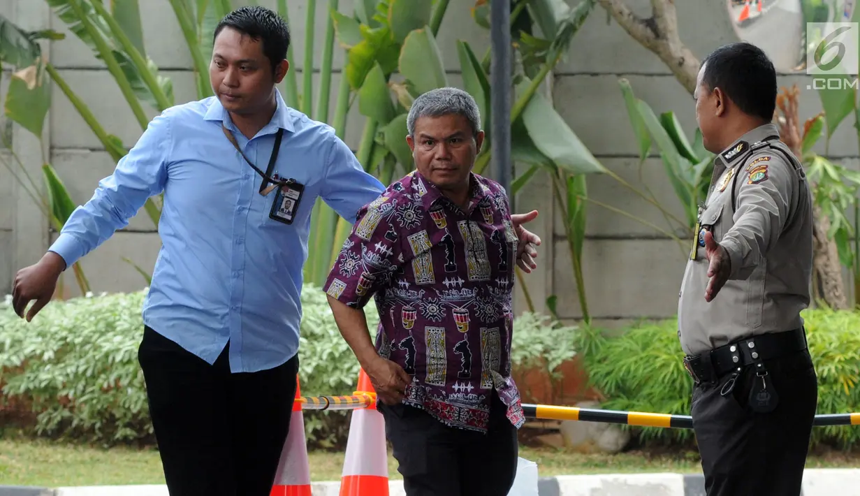 Petugas Pemeriksa Pajak Wilayah Maluku-Papua Sulimin Ratmin (batik), yang diamankan oleh KPK dalam OTT di Ambon, tiba untuk pemeriksaan di Jakarta, Kamis (4/10). KPK melakukan OTT terkait dengan pengurangan pembayaran pajak. (Merdeka.com/Dwi Narwoko)