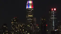 Lampu warna bendera juara Piala Dunia 2018, Prancis, mewarnai gedung pencakar langit Empire State di New York, Minggu (15/7). Meski gagal lolos Piala Dunia 2018, Amerika Serikat memiliki cara tersendiri memeriahkan ajang itu. (AFP PHOTO / KENA BETANCUR)