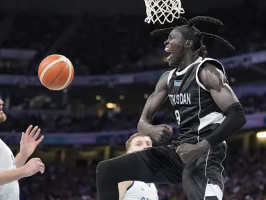 Pebasket Sudan Selatan Wenyen Gabriel (kanan) berselebrasi setelah melakukan dunk saat Nikola Jokic dari Serbia menonton selama pertandingan bola basket putra Olimpiade Paris 2024 di Villeneuve-d'Ascq, Sabtu, 3 Agustus 2024. (AP Photo/Michael Conroy)