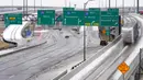 Rambu jalan berwarna kuning memperingatkan pengemudi tentang kondisi jalan licin di persimpangan IH 30 dan IH 35 yang sibuk, Dallas, Texas, Amerika Serikat, 1 Februari 2023. Badai yang menyelimuti Texas menyebabkan dua kematian di jalan-jalan yang licin. (AP Photo/Tony Gutierrez)