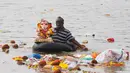 Seorang pria India membawa patung Dewa Ganesha dengan pelampung untuk dibenamkan ke dalam sungai Sabarmati di Ahmadabad, India, Selasa (5/9). Perayaan ini ditandai dengan pemasangan patung Dewa Ganesha di tiap rumah umat Hindu di India. (Ajit Solanki/AP) 