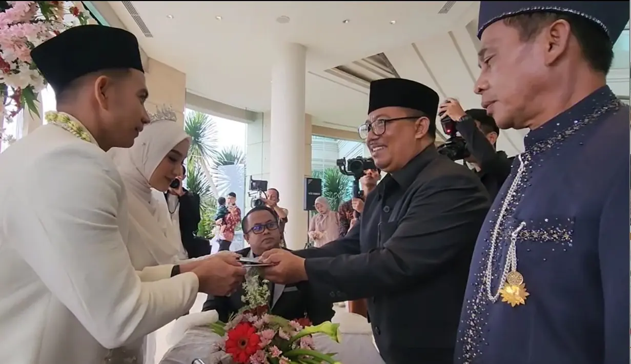 Dalam video yang beredar, Rizki dengan lancar mengucapkan ijab kabul. Dari ucapan wali nikah, Rizki memberikan mas kawin emas seberat 12 gram. Momen Rizki menerima buku nikah. [Instagram/da2_ridho]