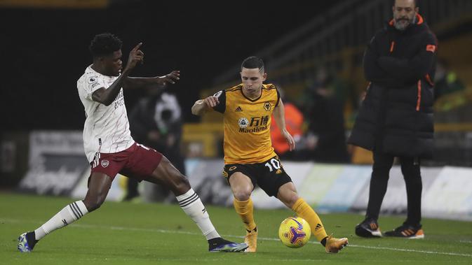 Gelandang Wolverhampton Wanderers, Daniel Podence berebut bola dengan gelandang Arsenal, Thomas Partey pada pekan ke-22 Liga Inggris di stadion Mollineux, Rabu (3/2/2021) dini hari WIB. Arsenal harus pulang dengan tangan hampa usai kalah 1-2 atas Wolverhampton. (Nick Potts/Pool via AP)