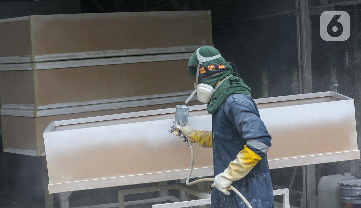 Pekerja mengecat peti mati Covid-19 di Rawa Mekar Jaya, Serpong, Tangerang Selatan, Kamis (21/01/2021). Produksi peti mati berbahan baku papan MDF meningkat cukup tinggi sejak bulan November 2020. (Liputan6.com/Fery Pradolo)