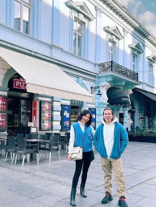 Berpose bersama Jordi Onsu di depan restoran, Sarwendah tampil stylish mengenakan turtleneck top warna krem dengan vest warna biru bersama mini skirt dan legging warna hitam. (Instagram/sarwendah29).