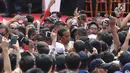 Presiden Joko Widodo (tengah) berjalan menembus kerumunan warga usai peresmian pengoperasian Moda Raya Terpadu Jakarta fase 1 di Kawasan Bundaran HI, Jakarta, Minggu (24/3). Acara ini sekaligus pencanangan pembangunan Moda Raya Terpadu Jakarta fase 2. (Liputan6.com/Helmi Fithriansyah)