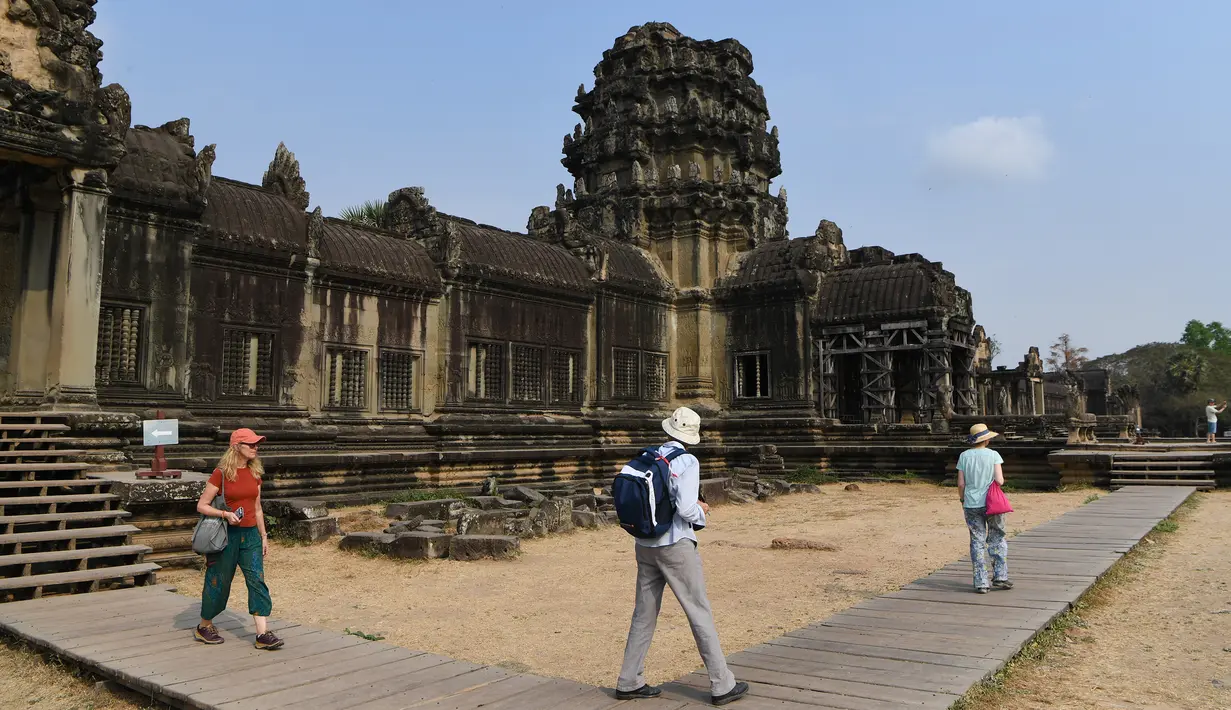 Sejumlah wisatawan berjalan di Candi Angkor Wat, Provinsi Siem Reap, Kamboja, Kamis (5/3/2020). Menurut World Travel and Tourism Council, wabah virus corona (COVID-19) membuat sektor pariwisata dunia kehilangan USD 22 miliar. (TANG CHHIN Sothy/AFP)